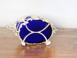 a blue glass bowl sitting on a wooden table