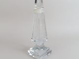 un bougeoir en verre transparent posé sur une surface blanche