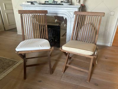two wooden chairs in front of a fireplace in a living room