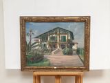 a painting of a house on a easel in front of a white wall