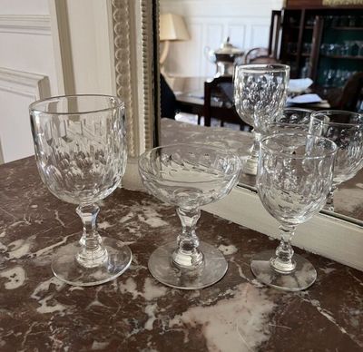 three wine glasses sitting on a table next to a mirror
