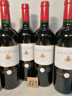 six bottles of red wine lined up on a table with a price tag