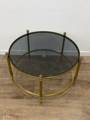 une table basse en verre et laiton avec un plateau rond en verre