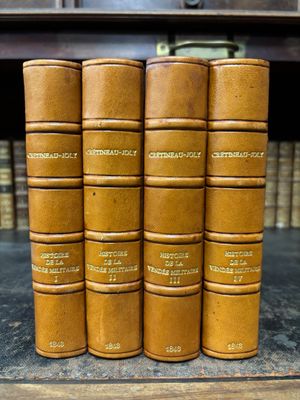 a row of old books sitting on top of a wooden shelf