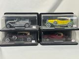 three model cars are in a display case on a white surface