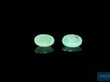 a pair of green jade stone earrings on a black background