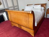 a bed with a wooden sleigh in the middle of a room