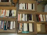 des boîtes de livres sont empilées dans une pièce