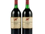 two bottles of red wine sitting next to each other on a white surface