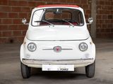 a small white car with a red top parked in front of a brick wall