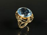 a gold ring with a blue topaz stone in the center