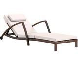 La chaise longue est en osier et est équipée d'un coussin blanc.