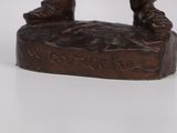 a bronze figurine of a man on a rock