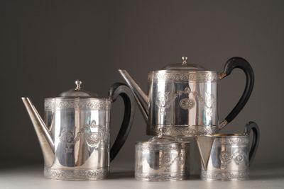 a silver tea set on a table next to cups and a teapot