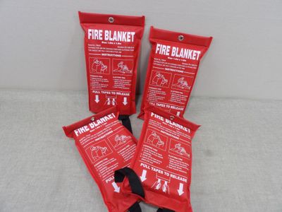three red fire blanket bags sitting on top of a white surface