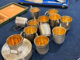 de nombreuses tasses et soucoupes posées sur une table, accompagnées d'argenterie
