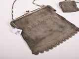 a small purse with a chain around it and a small purse with a tag attached to it
