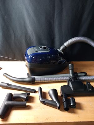 un aspirateur posé sur une table à côté d'autres objets