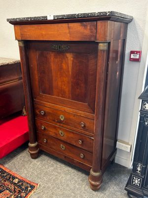 une commode en bois avec des tiroirs et une chaise rouge dans un coin