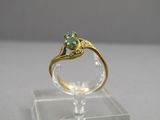 l'image d'une bague en or ornée d'une pierre verte