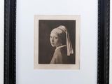an old black and white photo of a girl with a pearl ear