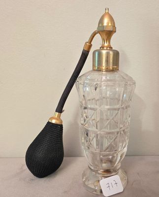 a glass bottle with a black handle and a black brush