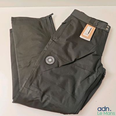 Le pantalon est noir et porte une étiquette