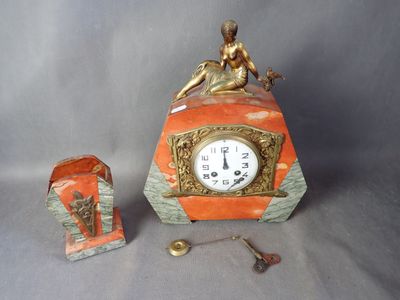 une petite horloge surmontée d'une statue
