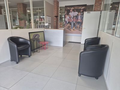 two black chairs in a room with a picture on the wall