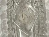 a clear glass bottle with a gold lid on a table