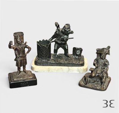 trois figurines en bronze représentant un homme et une femme assis sur un banc