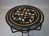 une table noire et dorée ornée d'un motif floral