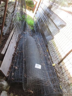 une clôture derrière laquelle se trouvent plusieurs animaux en cage