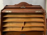 an old wooden desk with a lot of papers on it
