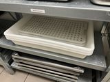 a stack of plastic trays sitting on top of a metal shelf