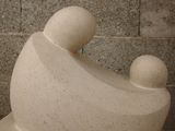 a white sculpture of a man and a woman sitting on a bench