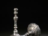 une paire de bougeoirs en argent sur fond noir