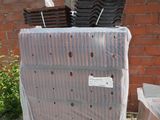 a pile of plastic sheets sitting on the ground next to a brick wall