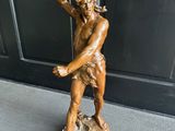 statue en bronze représentant un homme tenant un oiseau sur un rocher