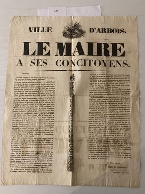 un vieux journal sur lequel est posé un stylo, posé à son tour sur une table