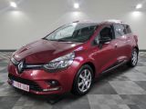 une voiture rouge est garée sur le sol en damier d'un garage