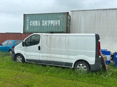 a white van parked in front of a shipping container