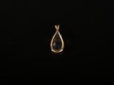 un pendentif doré en forme de larme sur fond noir