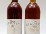 deux bouteilles de vin posées l'une à côté de l'autre sur une surface blanche