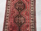 a red and black rug on a white floor