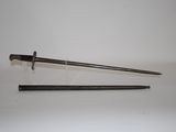 an old sword with a wooden handle sitting on top of a white surface