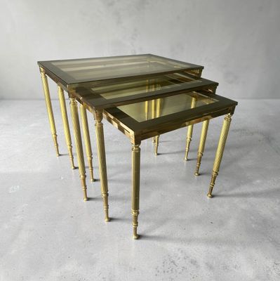 a set of three brass and glass nesting tables