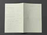 an open book with a handwritten letter on it sitting on a table