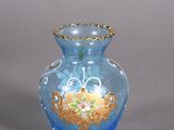 un vase en verre bleu orné d'un motif doré