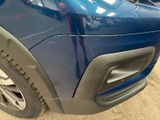 a close up of a blue car parked in a parking lot